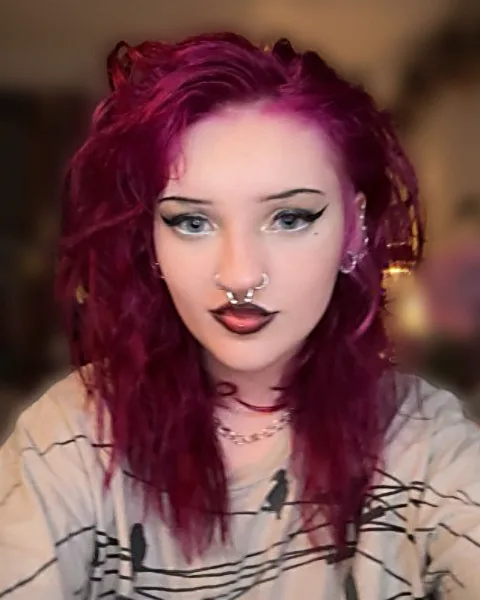 Noelle Carpenter with magenta hair and graphic liner