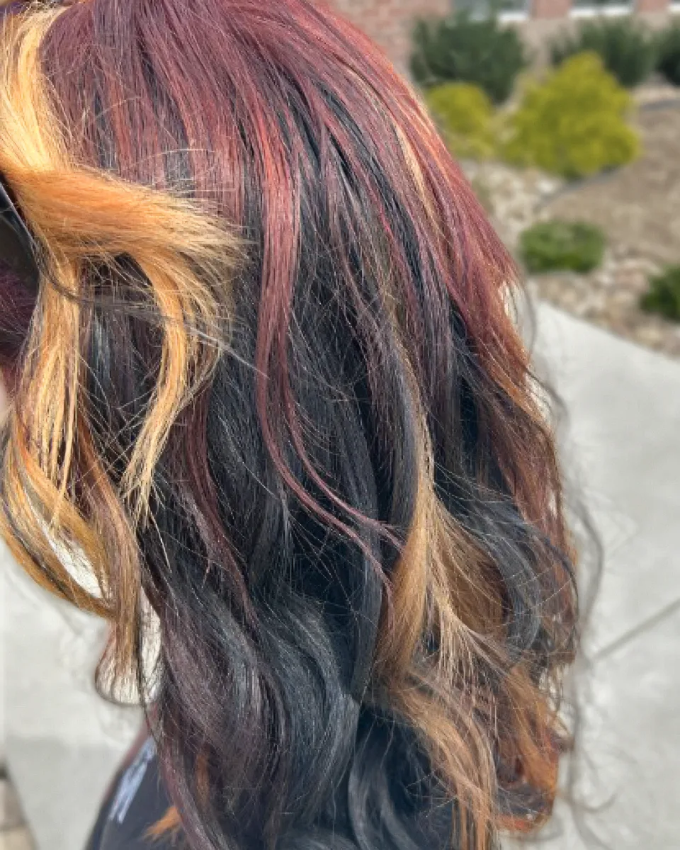 Burgundy, copper, and blonde dimensional color on dark hair